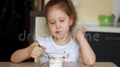 小女孩吃酸奶和奶酪加麦片。 儿童早餐食品乳制品